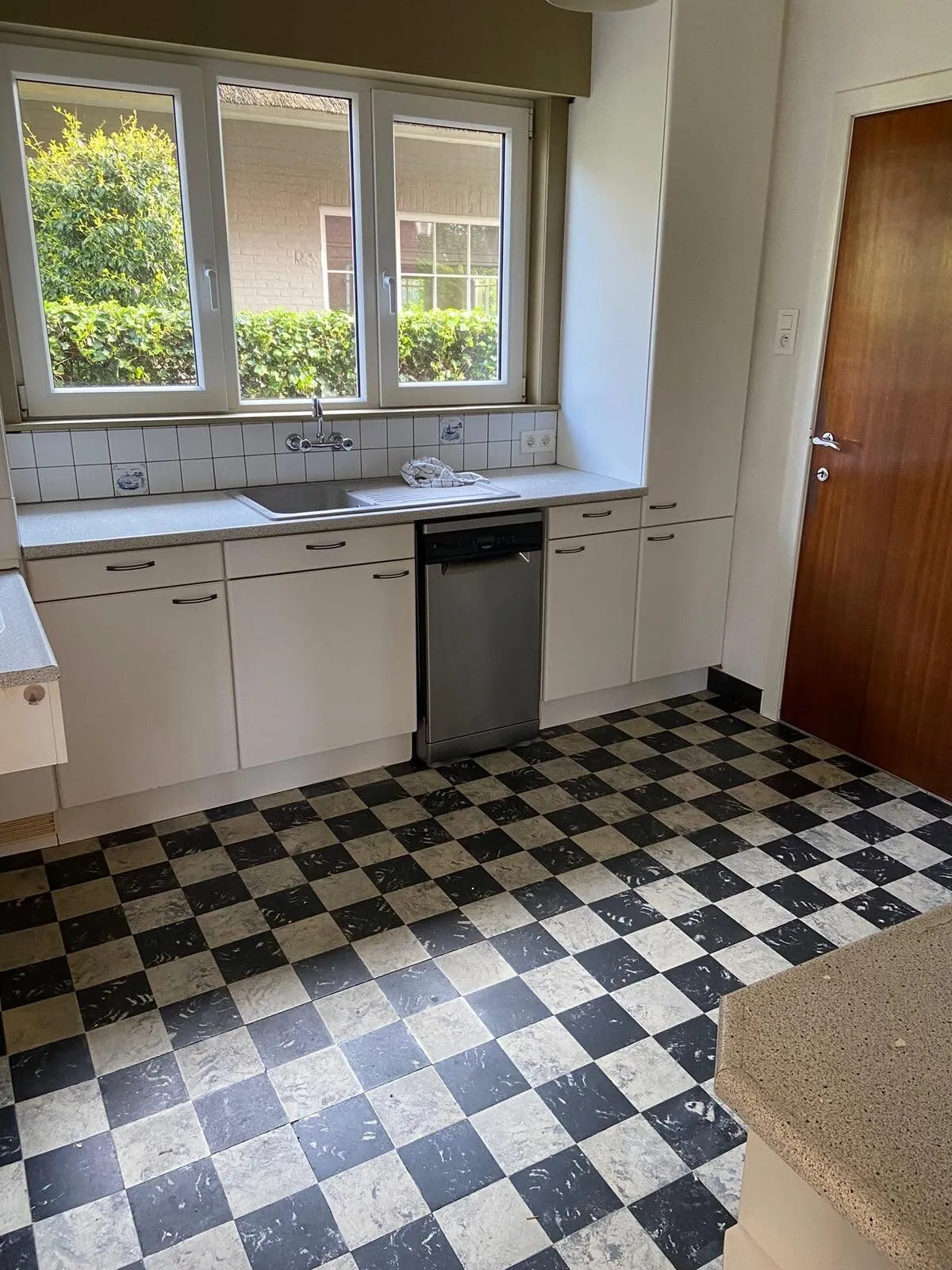 Oude keuken met zwart-witte tegelvloer