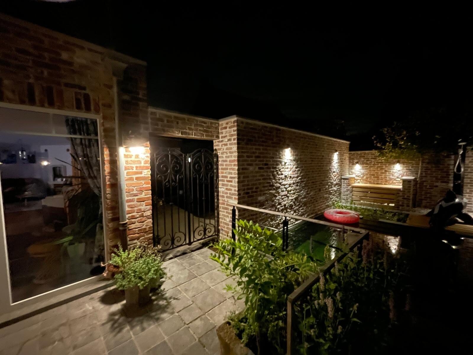 Tuinafsluiting in oude Brusselse recupsteen bij een zwemvijver